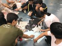 A Service Team member guiding the secondary school participants on a mass game during the summer camp